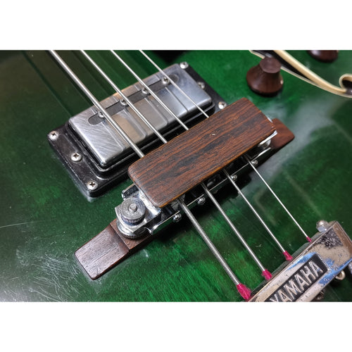 Custom wood string mute for arch top type bridge.